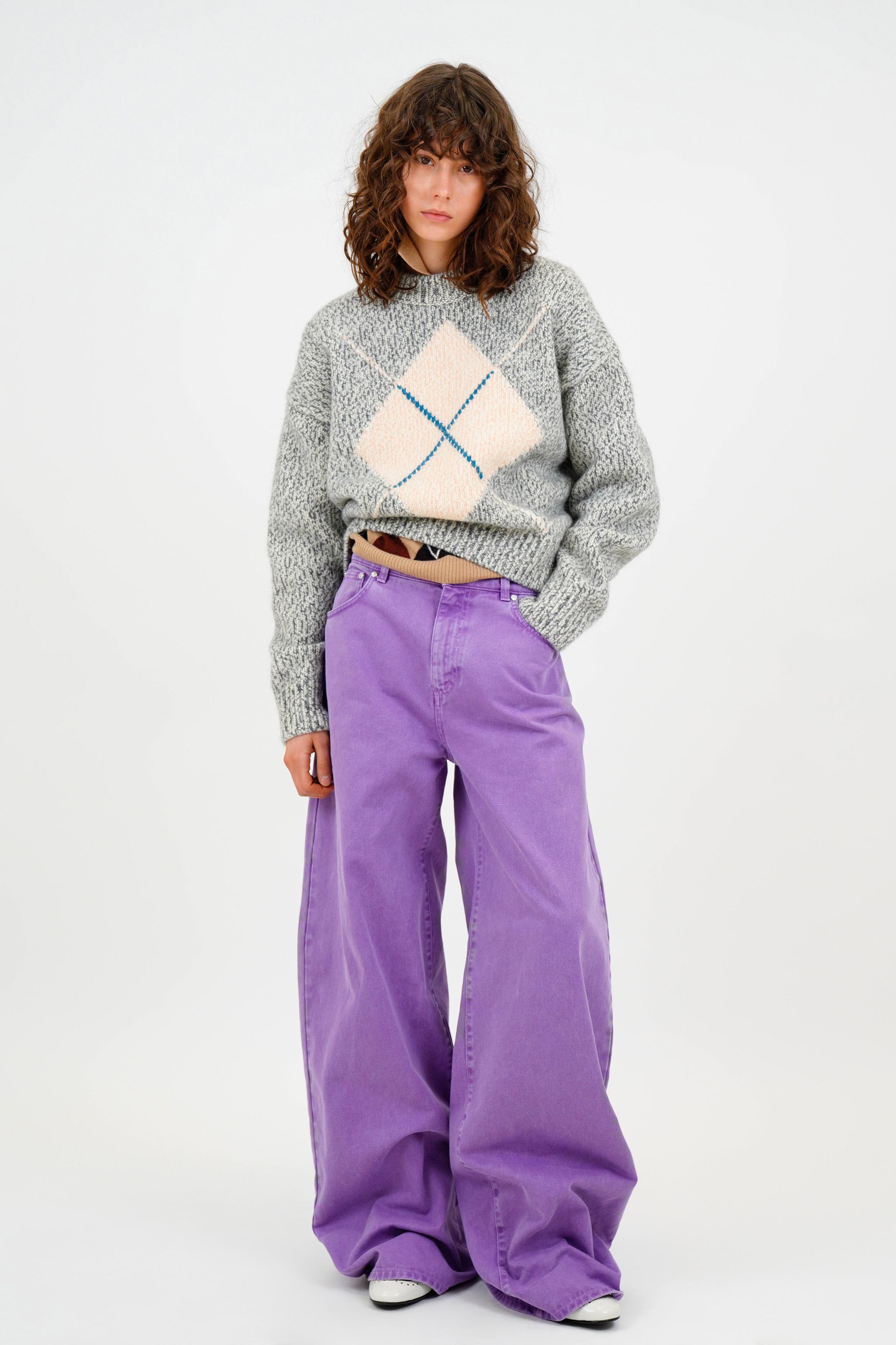 MSGM 2026秋冬以青年文化与学院风为切口，重新激活90年代街头记忆。宽腿彩色牛仔、菱格针织、短款上装与随性叠穿构建出不受性别限制的造型语言，紫色、亮蓝与黑白对比成为视觉焦点。系列在“玩味”与“结构”之间取得平衡，保留品牌标志性的青春躁动，同时注入更成熟的造型逻辑，呈现出Z世代走向理性阶段的风格转折-顽石频道趋势研究